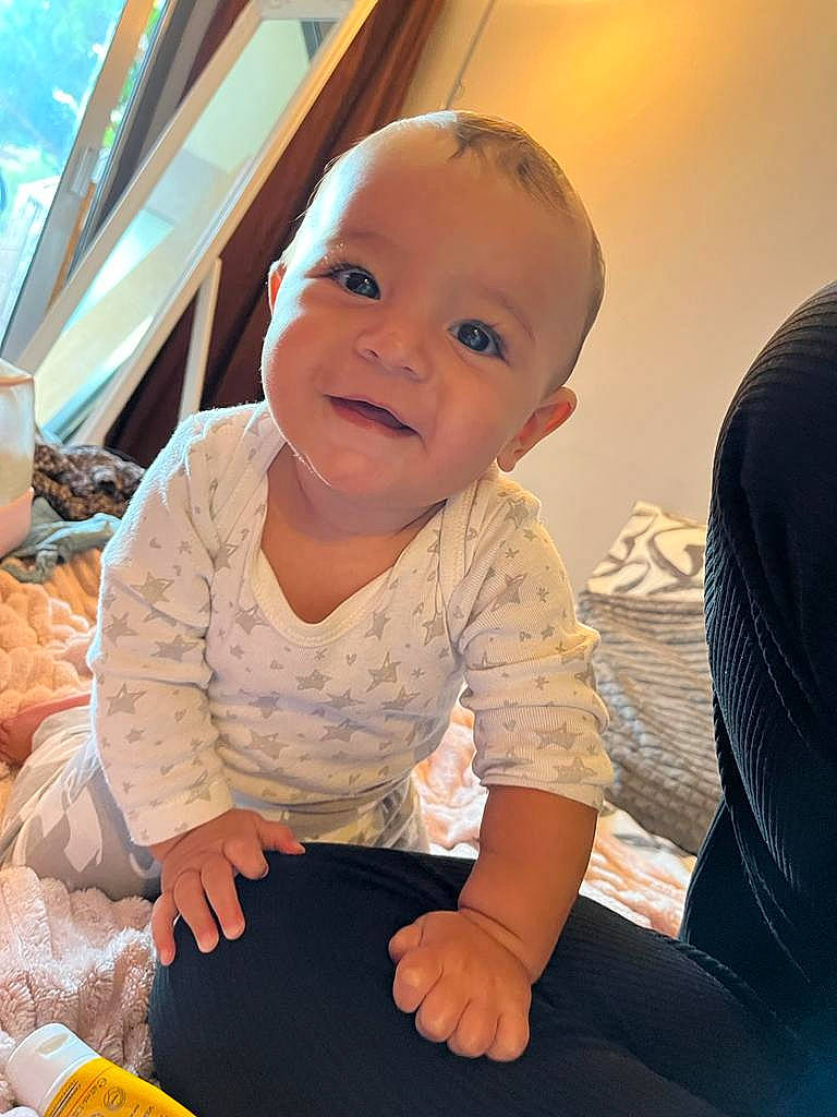 Giuliana participe au concours pour gagner de l'argent avec cette photo : baby, baby_toddler_clothing, cheek, child, chin, comfort, facial_expression, flash_photography, flooring, fun, happy, iris, leisure, person, sitting, skin, sleeve, smile, t_shirt, toddler