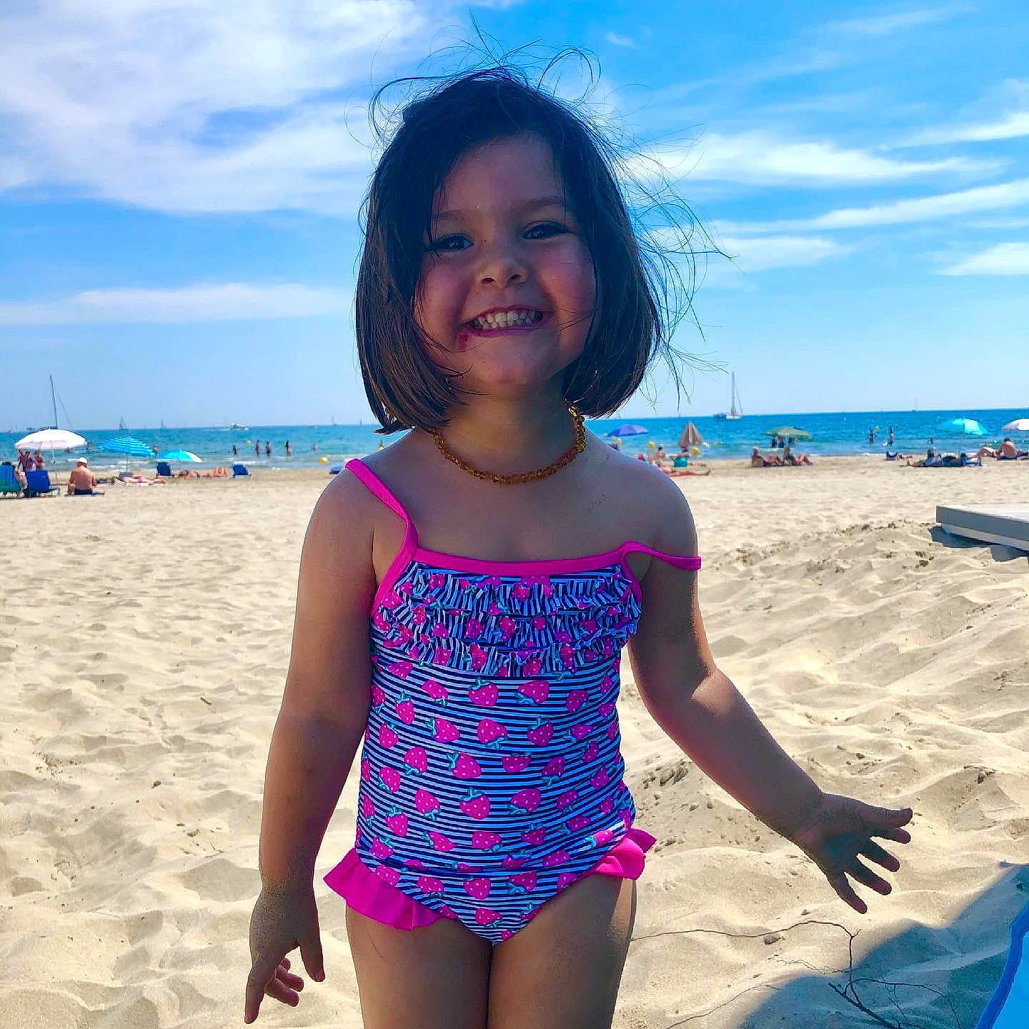 Melek a rejoint le concours — aidez-le/la à gagner de superbes lots ! aqua, beach, blue, cloud, fun, hair, happy, joy, leisure, morning, natural_environment, one_piece_swimsuit, people_on_beach, person, photograph, sky, smile, swimwear, thigh, toddler