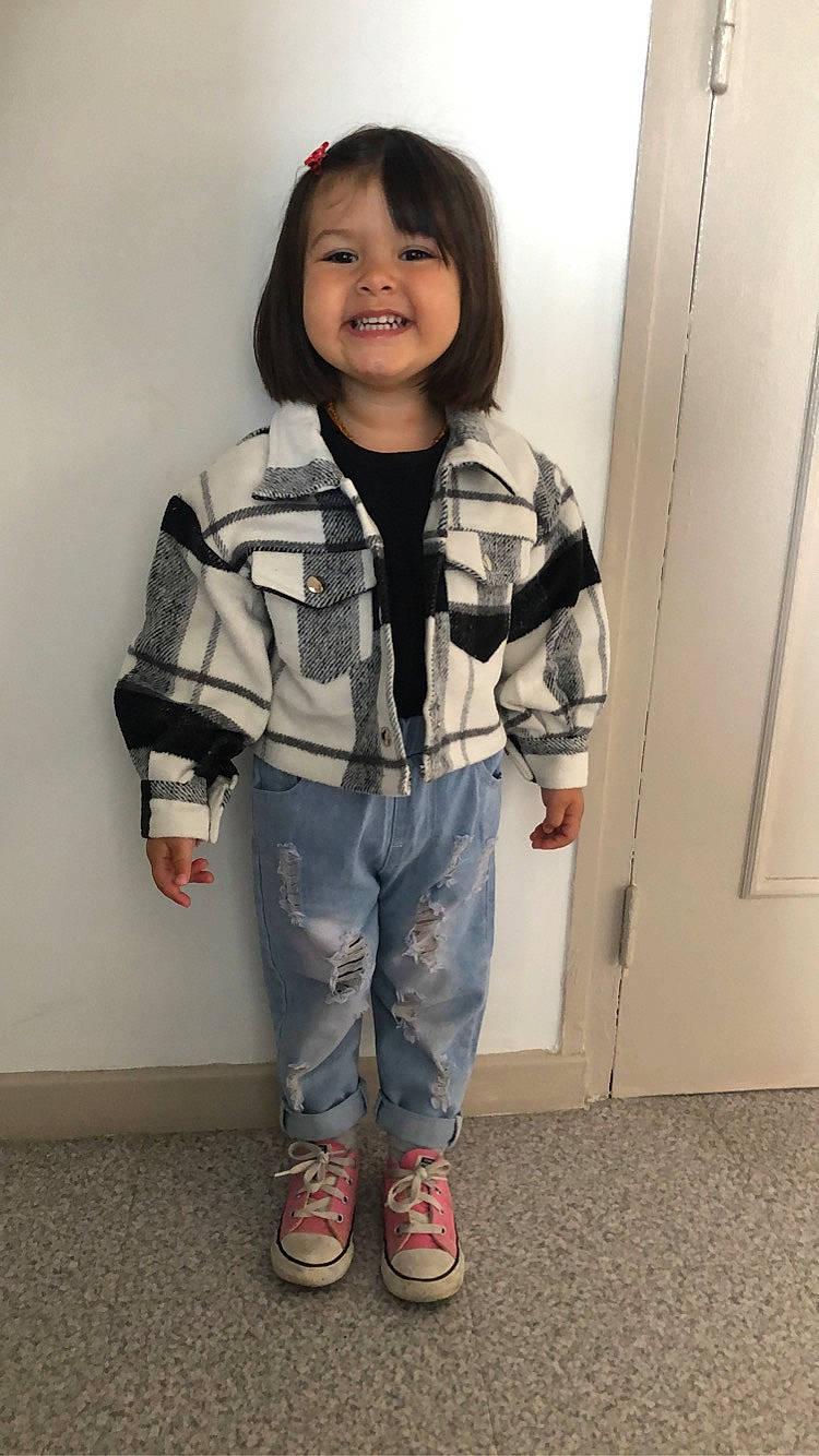 Melek participe au concours pour gagner de l'argent avec cette photo : baby_toddler_clothing, bag, child, collar, denim, flooring, gesture, happy, joy, leg, luggage_and_bags, pattern, person, room, sitting, sleeve, smile, sneakers, standing, thumb