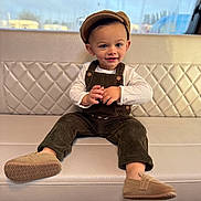 ésaïe participe au concours pour gagner de l'argent avec cette photo : baby, beige, cap, child, clothing, corduroy, couch, cute, footwear, happy, hat, indoor, overalls, person, portrait, quilted, shoe, sitting, smiling, toddler
