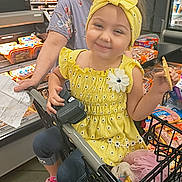 Millianna is registered to the contest to win money with this photo: adult, child, e_scooter, face, female, food, girl, grocerystore, head, indoors, market, person, photography, portrait, shop, supermarket, sweets, transportation, vehicle, woman