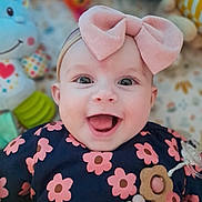 Charline a rejoint le concours — aidez-le/la à gagner de superbes lots ! accessory, apparel, baby, background, bow, cheerful, child, closeup, clothing, cute, face, flower_pattern, happy, headband, indoors, infant, plush, portrait, smiling, toy