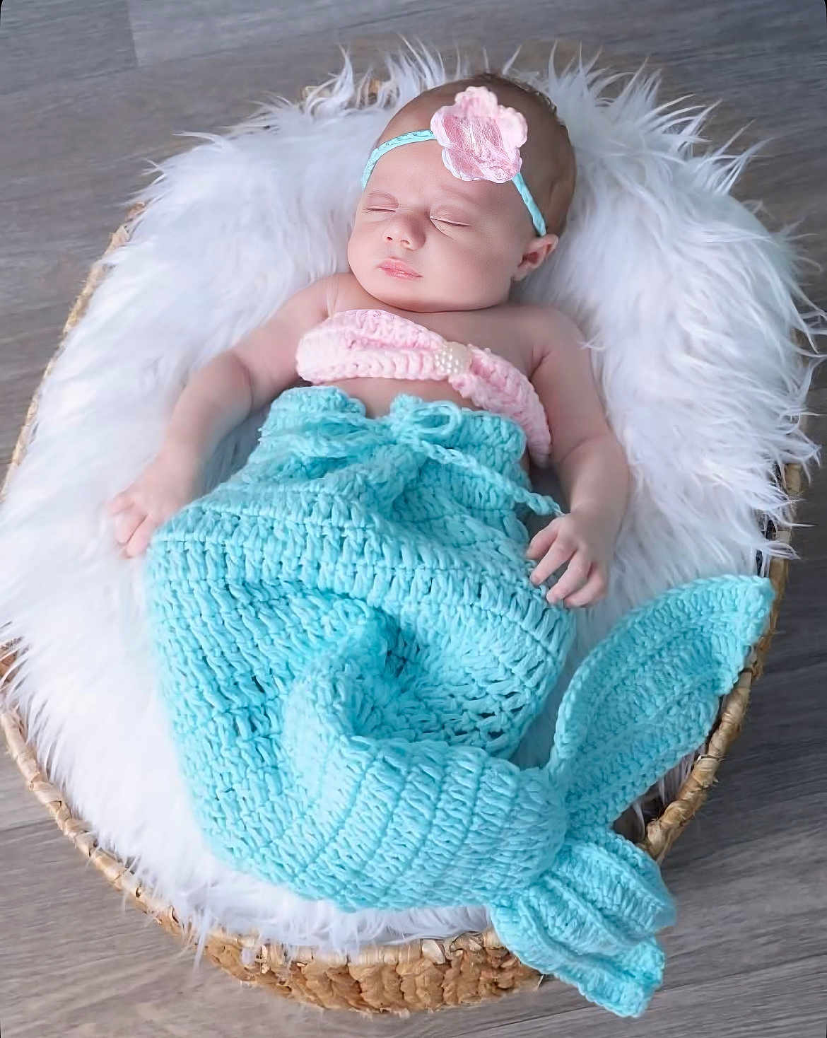 Khloe joined the competition — help win amazing prizes! baby, sleeping, mermaid_tail, knitted, headband, pink, turquoise, basket, fur, cozy, cute, infant, floor, wooden_floor, soft_texture, peaceful, portrait, indoors, resting, child