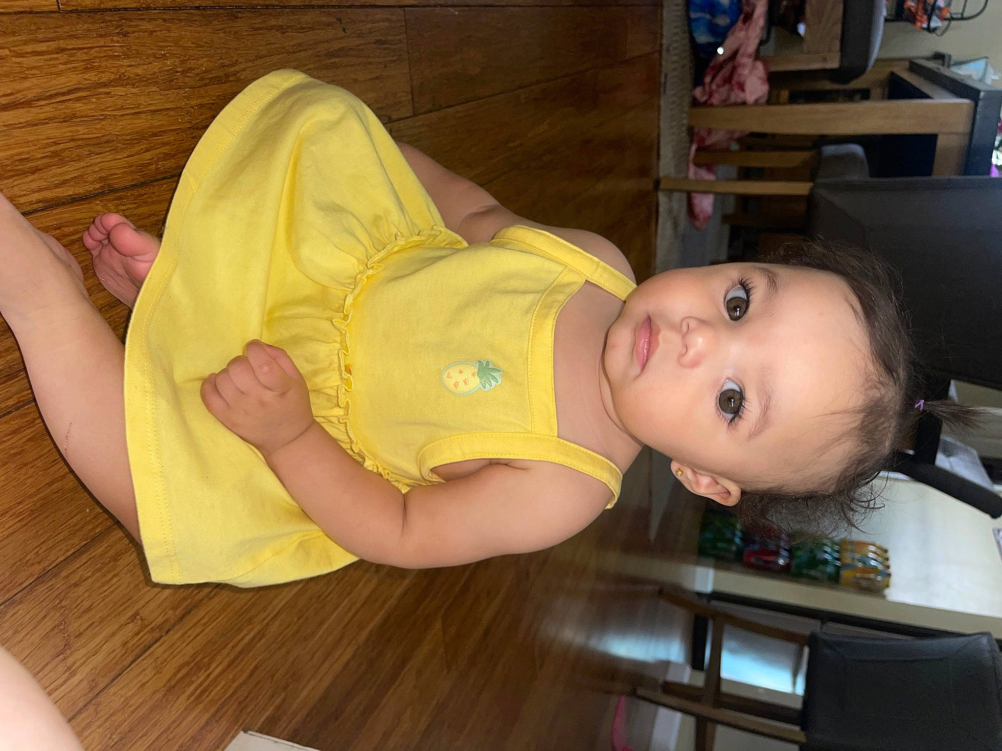 Luna joined the competition — help win amazing prizes! baby, baby_products, baby_toddler_clothing, child, comfort, flooring, foot, fun, hardwood, human_leg, knee, person, room, shelf, sitting, smile, thigh, toddler, varnish, wood