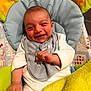 baby, smiling, infant, bib, blanket, padded_chair, cushion, white_clothing, happy, face, hand, head, indoor, baby_bed, child, person, soft_toys, yellow_blanket, home, cute