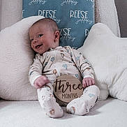 Reese joined the competition — help win amazing prizes! baby, infant, smile, onesie, pillow, star_pillow, cloud_pillow, chair, fluffy, cozy, indoor, child, cute, happy, person, newborn, sitting, wooden_sign, three_months, relaxing