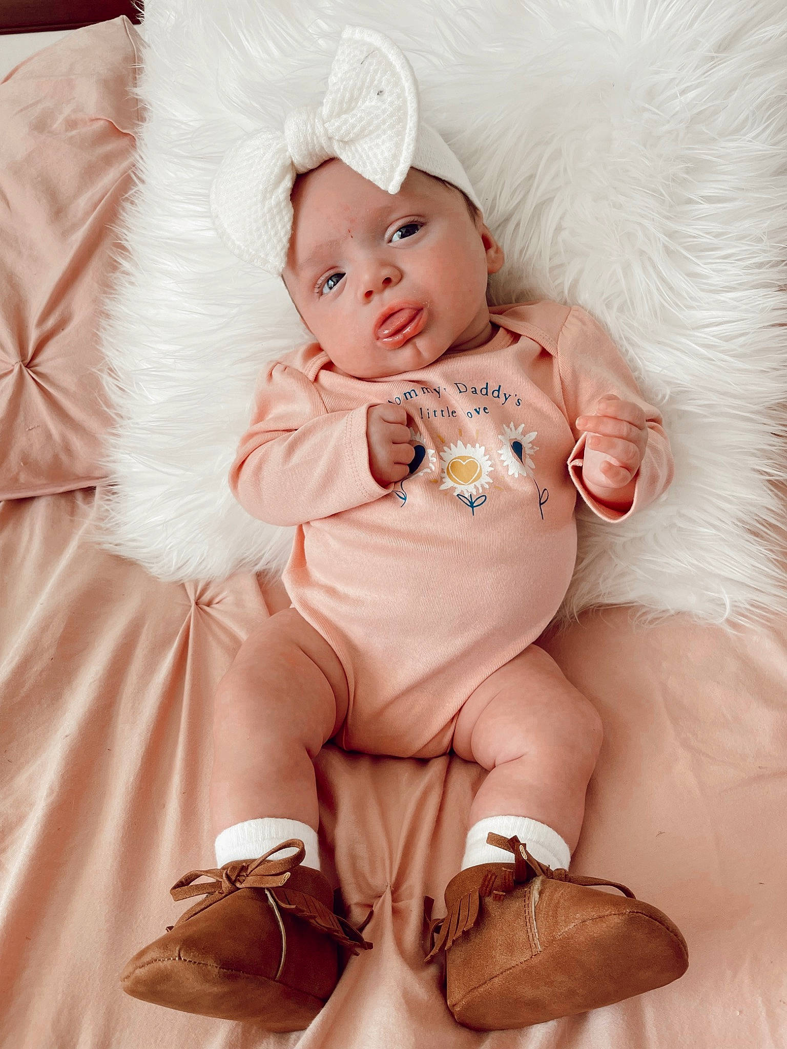 Madelynn is registered to the contest to win money with this photo: baby, baby_toddler_clothing, child, comfort, dress, fashion_accessory, fur, happy, headband, headpiece, headwear, human_leg, jewellery, knee, peach, person, pink, sitting, skin, textile