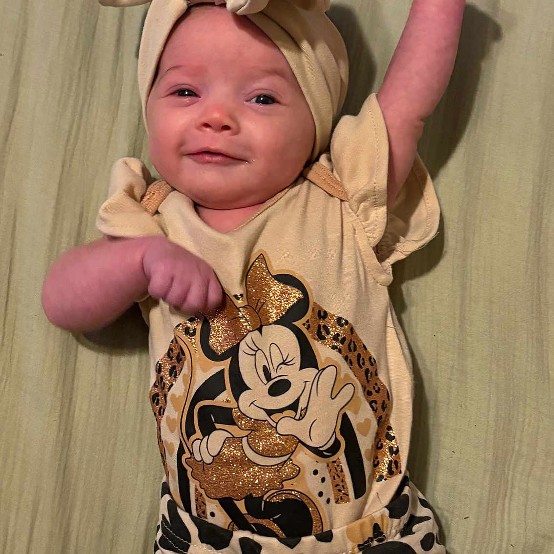 Liyana joined the competition — help win amazing prizes! animal_print, apparel, baby, bow, cartoon, child, clothing, cute, face, fashion, happy, headband, infant, lying_down, minnie_mouse, patterned_pants, person, raised_arm, smile, soft_surface