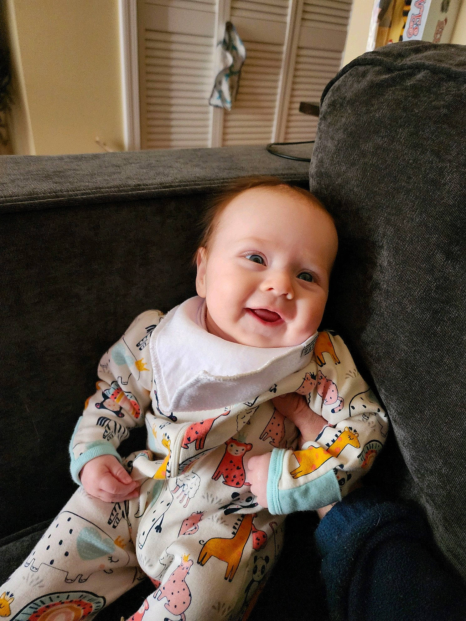 Ainsley is registered to the contest to win money with this photo: baby, baby_toddler_clothing, chair, cheek, child, comfort, couch, eye, flooring, happy, human_body, iris, lap, person, room, sitting, skin, sleeve, smile, toddler