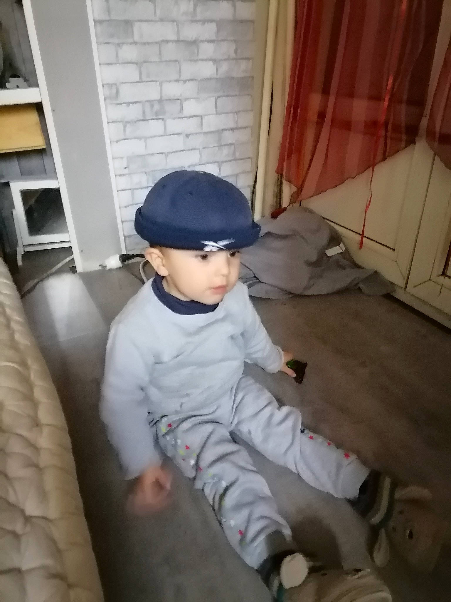 Damien participe au concours pour gagner de l'argent avec cette photo : baby_toddler_clothing, baseball_cap, cap, chair, child, comfort, concrete, door, floor, flooring, hardwood, hat, headwear, helmet, person, personal_protective_equipment, room, sitting, t_shirt, toddler