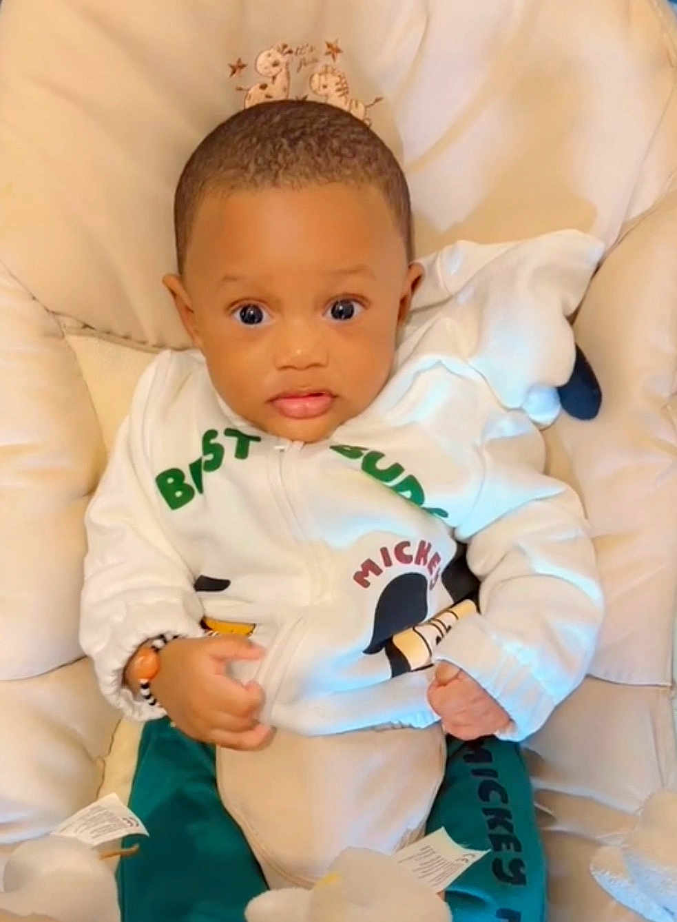 Dao Yerim participe au concours pour gagner de l'argent avec cette photo : baby, child, infant, cushion, clothing, mickey_mouse, jacket, pants, face, eyes, hands, seated, indoor, cute, expression, person, soft, comfort, young, adorable