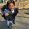 Dwane joined the competition — help win amazing prizes! toddler, child, swing, playground, denim_jacket, denim_pants, cap, black_shoes, outdoor, sunlight, smiling, happy, person, play, fun, metal_chain, rubber_swing_seat, concrete_floor, fence, shadow