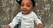 Dwane joined the competition — help win amazing prizes! toddler, child, smiling, baseball_cap, pacifier, outdoor, jeans, white_shirt, standing, stone_wall, texture, happy, cute, person, young_child, casual_clothing, nature, leaf_litter, daylight, portrait