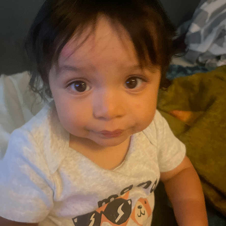 Miguel joined the competition — help win amazing prizes! applique, baby, bodypart, clothing, couch, face, finger, furniture, hand, happy, head, indoors, mouth, person, photography, portrait, shirt, sitting, smile, t_shirt