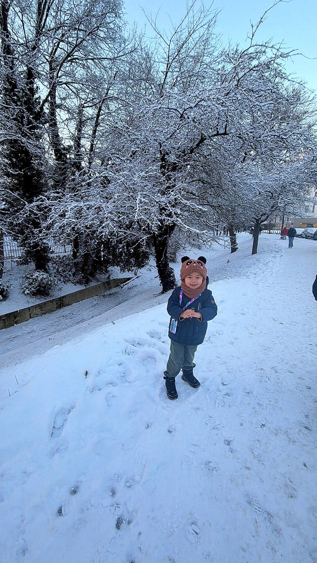 Nyingjey participe au concours pour gagner de l'argent avec cette photo : child, snow, winter_clothing, hat, scarf, boots, trees, snowy_path, outdoor, smiling, cold_weather, park, nature, footprints, person, blue_sky, daylight, forest, winter, scenic