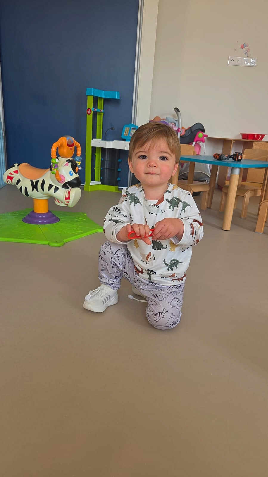 Naël a rejoint le concours — aidez-le/la à gagner de superbes lots ! toddler, child, indoor, playroom, toy, dinosaur_clothing, kneeling, floor, table, chair, plastic_toy, colorful, young_child, person, casual_clothing, cute, play, baby, furniture, smiling