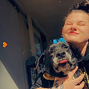 Nikki joined the competition — help win amazing prizes! person, dog, hugging, smile, sunlight, porch, tattoo, earrings, hoodie, black_dog, tongue_out, happy, closeup, outdoor, door, window, hand, heart_emoji, casual, home