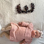 Iris participe au concours pour gagner de l'argent avec cette photo : baby, infant, blanket, knitted_clothing, headband, grapes, fruit, lying_down, soft_texture, pink, beige, cute, child, toddler, cozy, portrait, indoors, still_life, playful, arrangement