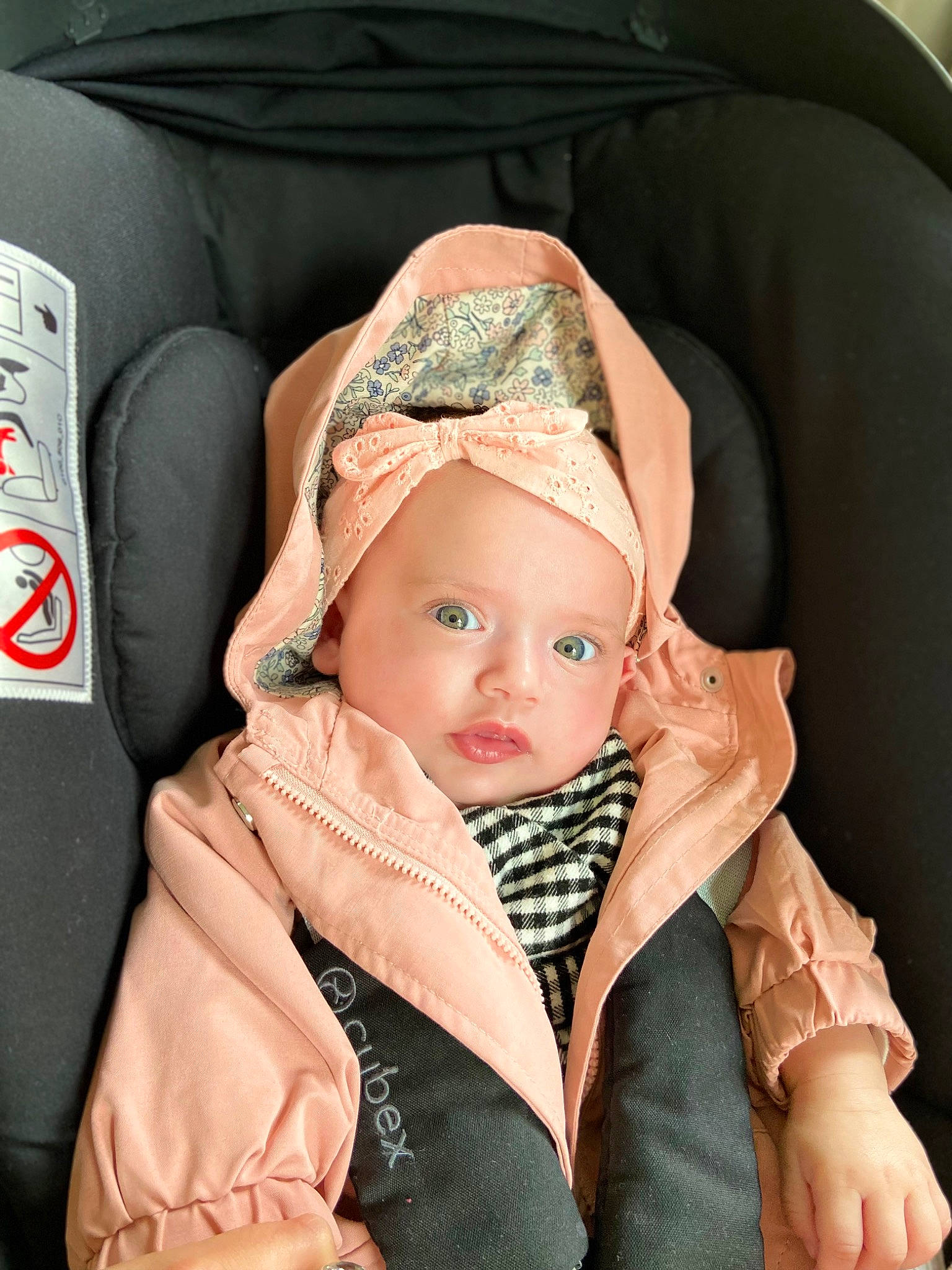 Nelya participe au concours pour gagner de l'argent avec cette photo : baby, baby_products, baby_toddler_clothing, beanie, cap, car_seat, child, collar, comfort, fashion_accessory, fur, headgear, headwear, linens, pattern, peach, person, personal_protective_equipment, scarf, sitting
