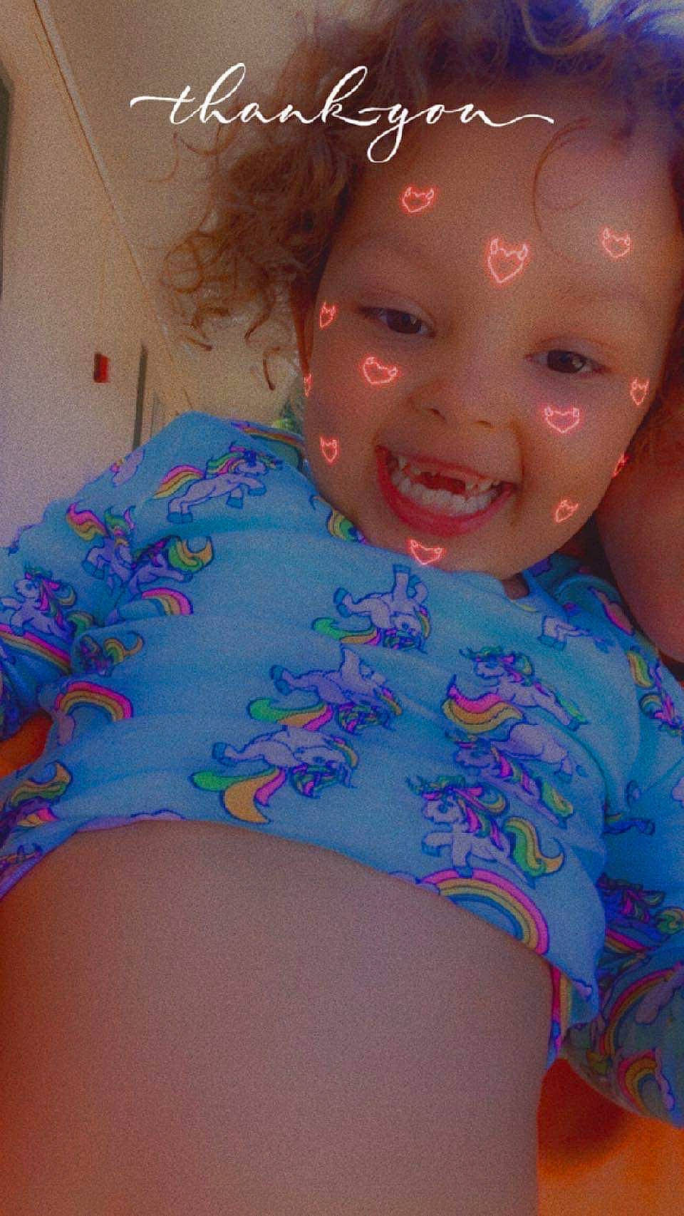 Riley is registered to the contest to win money with this photo: arm, chest, chin, eye, face, hair, happy, head, human_body, iris, joy, lip, mouth, neck, person, pink, shoulder, skin, smile, stomach