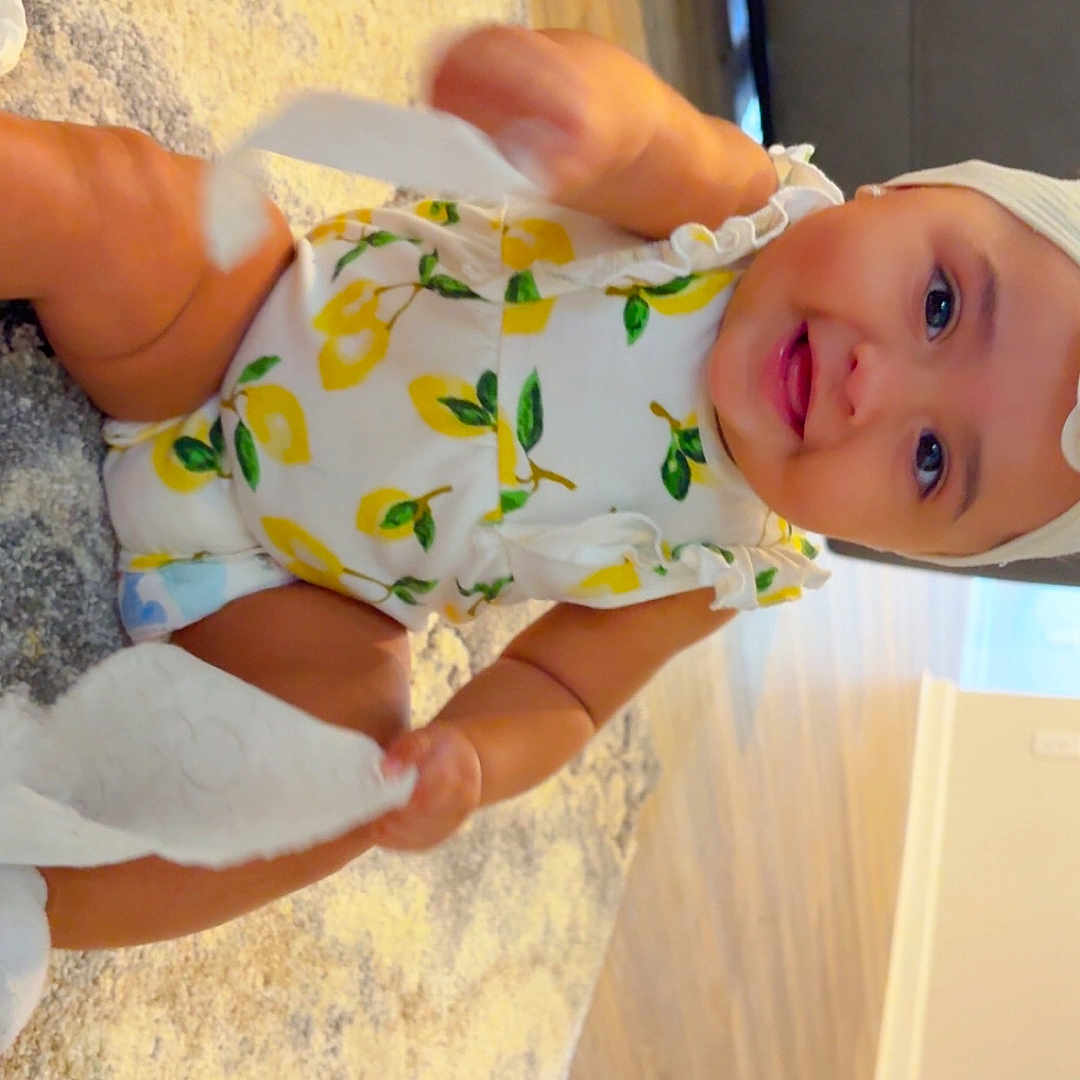 Kiyomi is registered to the contest to win money with this photo: baby, carpet, child, clothing, cute, diaper, floor, furniture, happy, hat, headwear, home, indoor, infant, patterned_clothing, person, playing, smiling, tissue_paper, wooden_floor