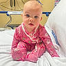 baby, infant, pink_clothing, floral_pattern, hospital_bed, medical_equipment, white_bed, child, cute, sitting, indoors, person, young_child, onesie, expression, blue_eyes, head, face, pajamas, hospital_room