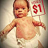 Izaiah is registered to the contest to win money with this photo: baby, infant, diaper, blanket, face, sign, hand, skin, red_marks, moawk_hair, cute, lying_down, advertisement, expressionless, child, person, humor, kisses, white_background, portrait
