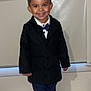 Denver a rejoint le concours — aidez-le/la à gagner de superbes lots ! child, boy, smiling, indoors, clothing, coat, bow_tie, pants, shoes, white_shirt, standing, happy, portrait, face, hair, window, curtain, floor, pillow, blanket