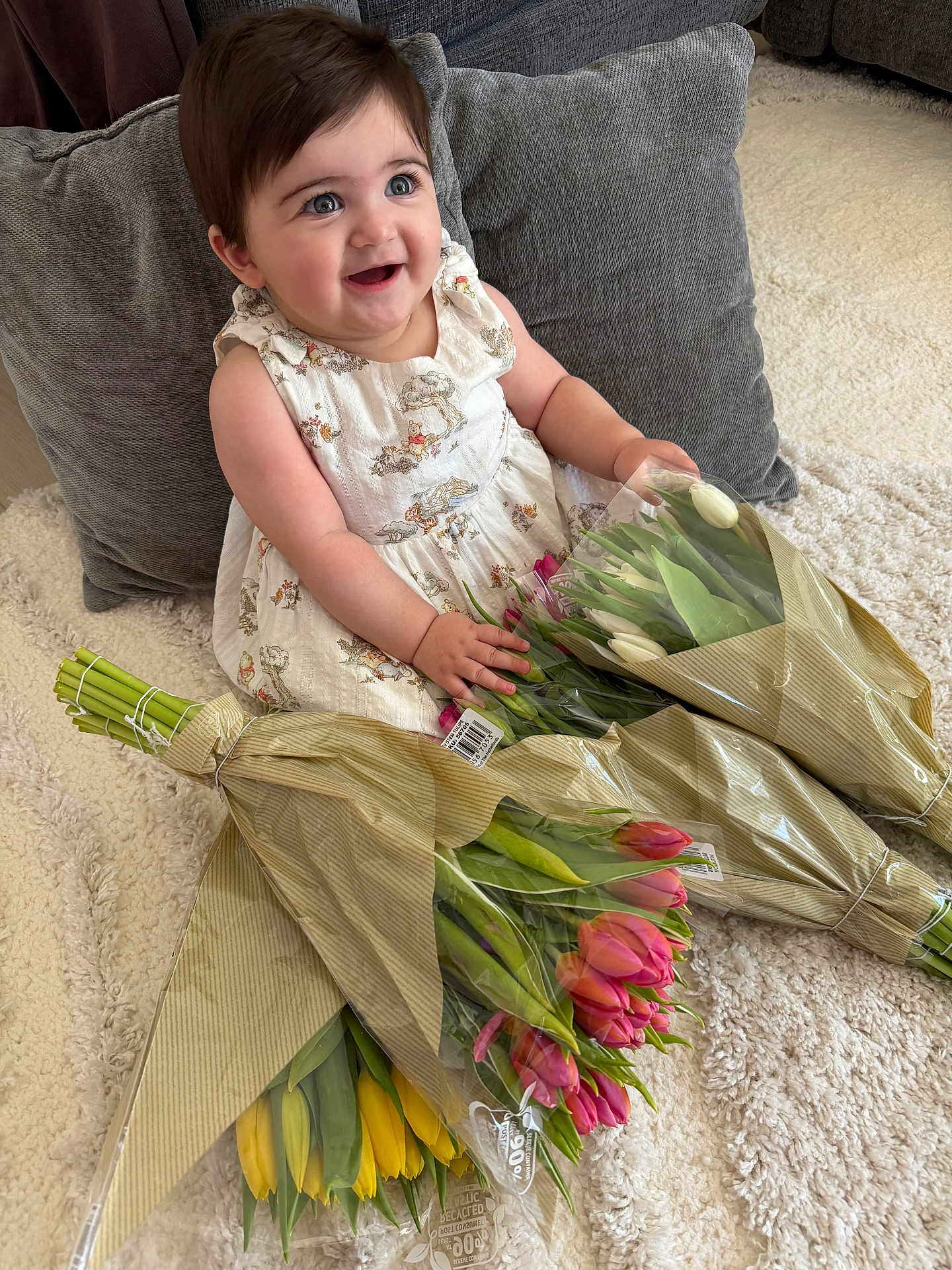 Vivienne joined the competition — help win amazing prizes! baby, child, tulips, flowers, bouquets, carpet, pillow, dress, smile, happy, indoor, person, plant, green, yellow, pink, white, sitting, cute, cozy