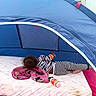 Jaleyah is registered to the contest to win money with this photo: child, toddler, baby, sleeping, lying_down, play_tent, indoor, outdoor, blanket, mattress, striped_clothing, curly_hair, pink_blanket, drink_bottle, tent, camping, playground, relaxing, portrait, daylight