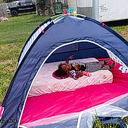 Jaleyah is registered to the contest to win money with this photo: child, toddler, smiling, outdoor, tent, camping, backyard, grass, mattress, sleeping_bag, pajamas, striped_clothing, toy, playground, playhouse, recreation, family, portrait, daylight, truck
