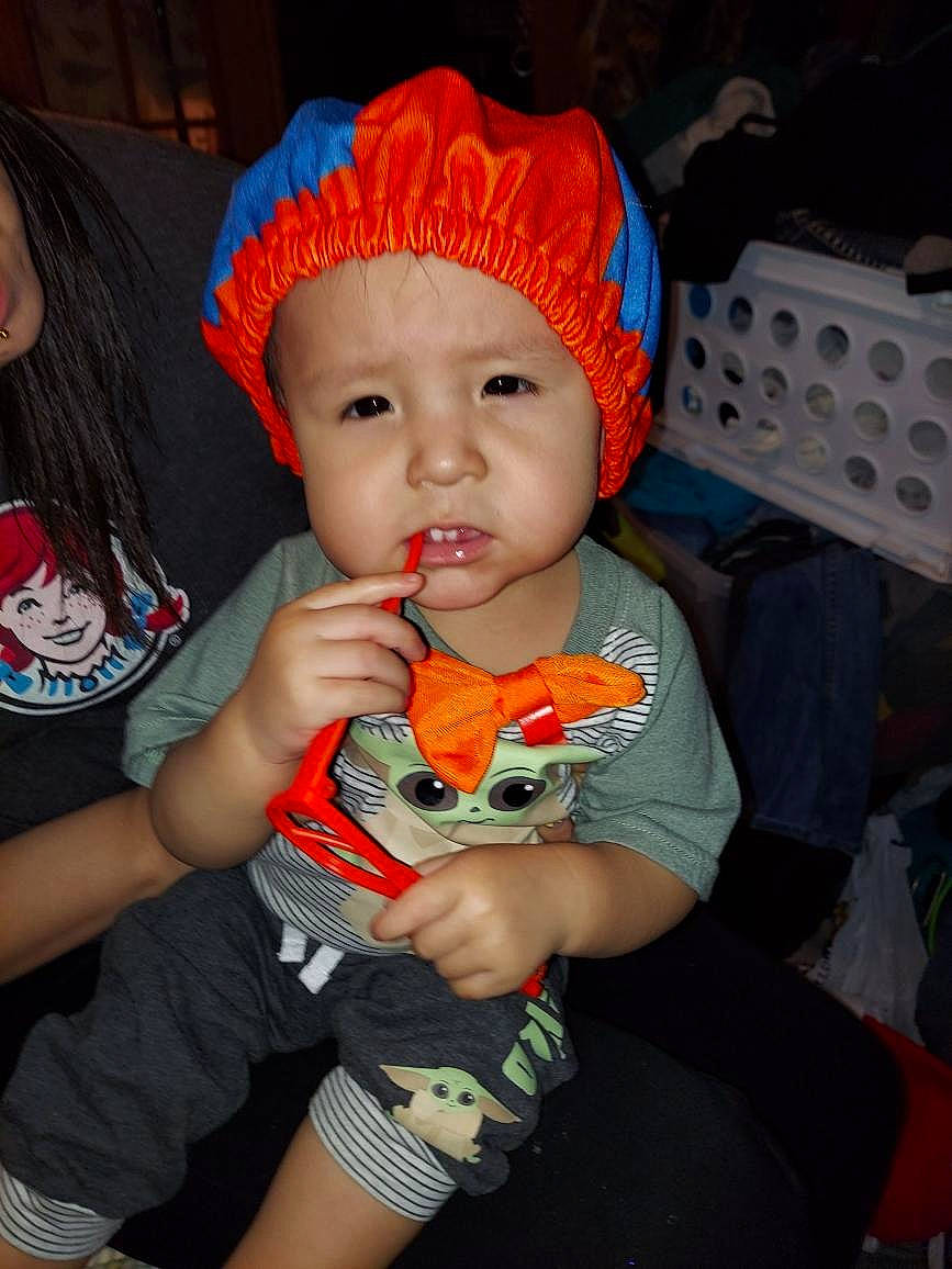 Xzavier is registered to the contest to win money with this photo: arm, baby, baby_products, baby_toddler_clothing, bonnet, bracelet, child, cool, eye, finger, hand, headwear, nail, nose, orange, overall, person, play, stuffed_toy, thumb