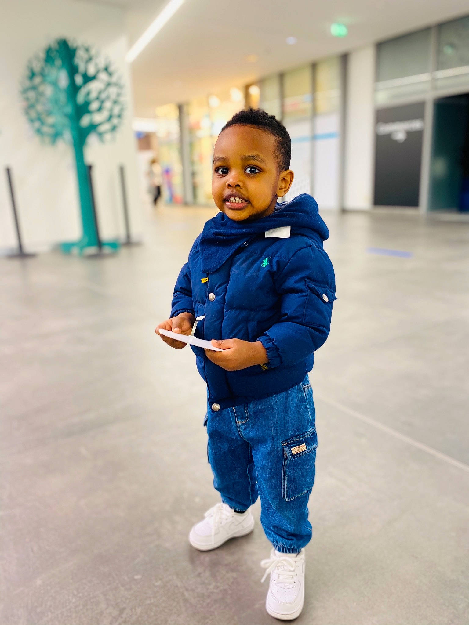 Kyle participe au concours pour gagner de l'argent avec cette photo : baby, baby_toddler_clothing, blue, child, denim, electric_blue, floor, flooring, fun, happy, houseplant, leg, leisure, people, person, sitting, sleeve, smile, standing, toddler
