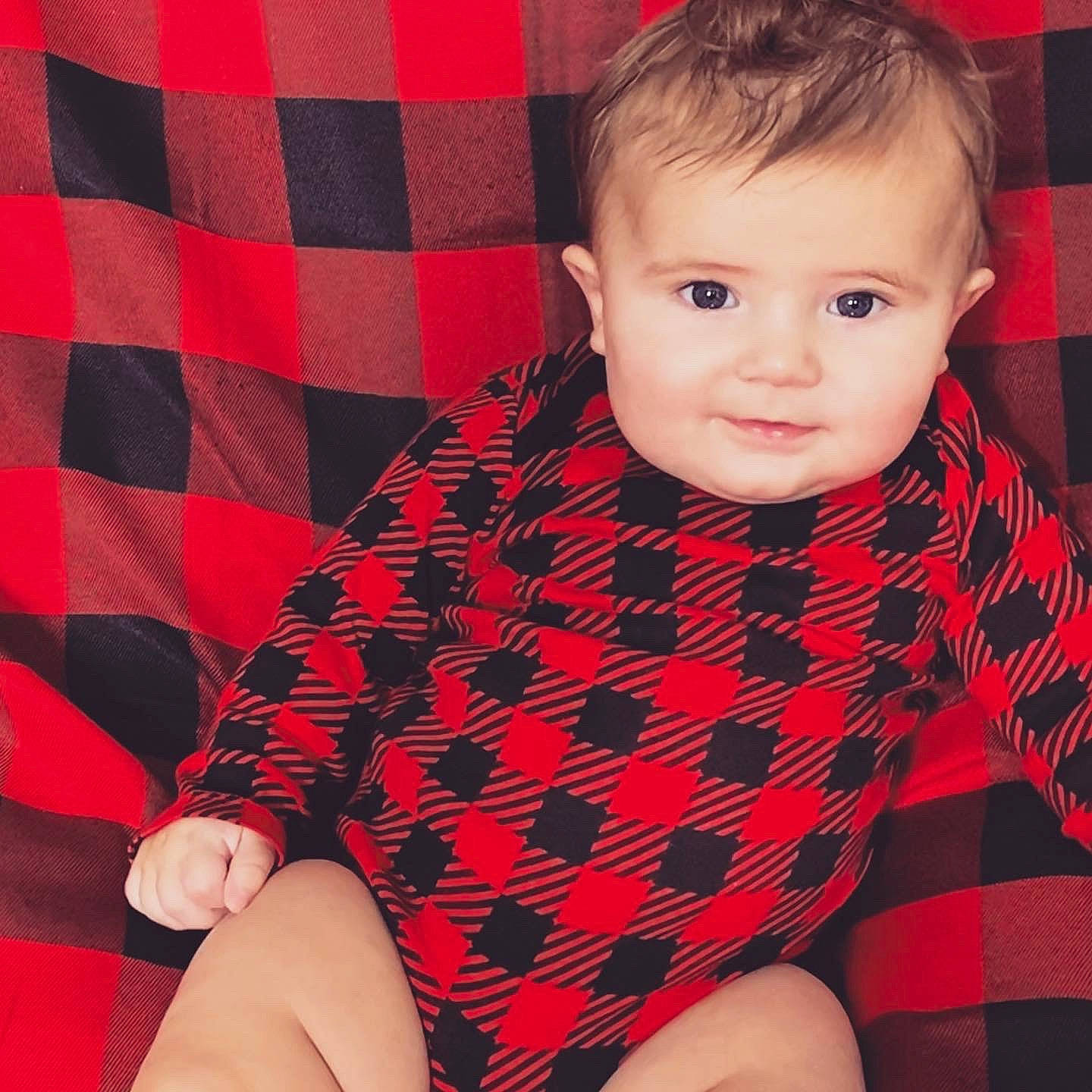 Matteo is registered to the contest to win money with this photo: baby, beauty, cheek, child, child_model, design, eye, face, hand, head, lip, outerwear, pattern, person, plaid, red, skin, sleeve, tartan, textile