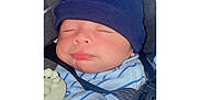 Jayden is registered to the contest to win money with this photo: newborn, baby, sleeping, hat, blue_stripes, car_seat, seatbelt, toy, infant, clothing, child, face, peaceful, cuteness, indoors, portrait, closeup, rest, bundle, cozy