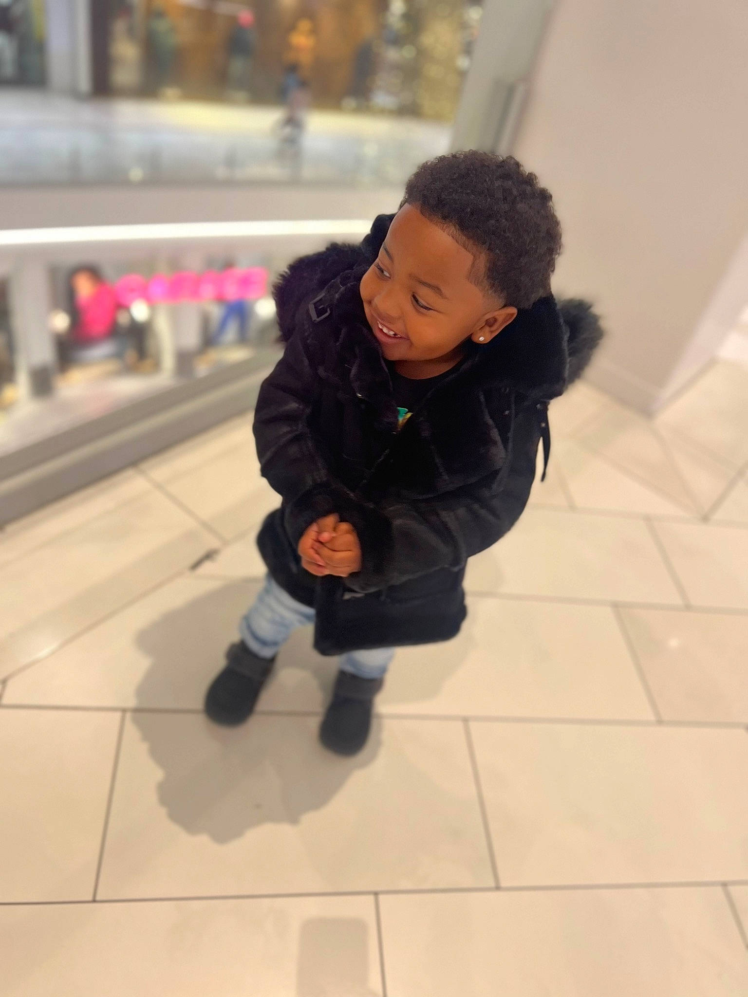 Markell is registered to the contest to win money with this photo: baby, bag, boot, child, floor, flooring, fun, fur, hoodie, human_leg, jacket, joy, leisure, luggage_and_bags, pedestrian, person, recreation, sitting, street, toddler