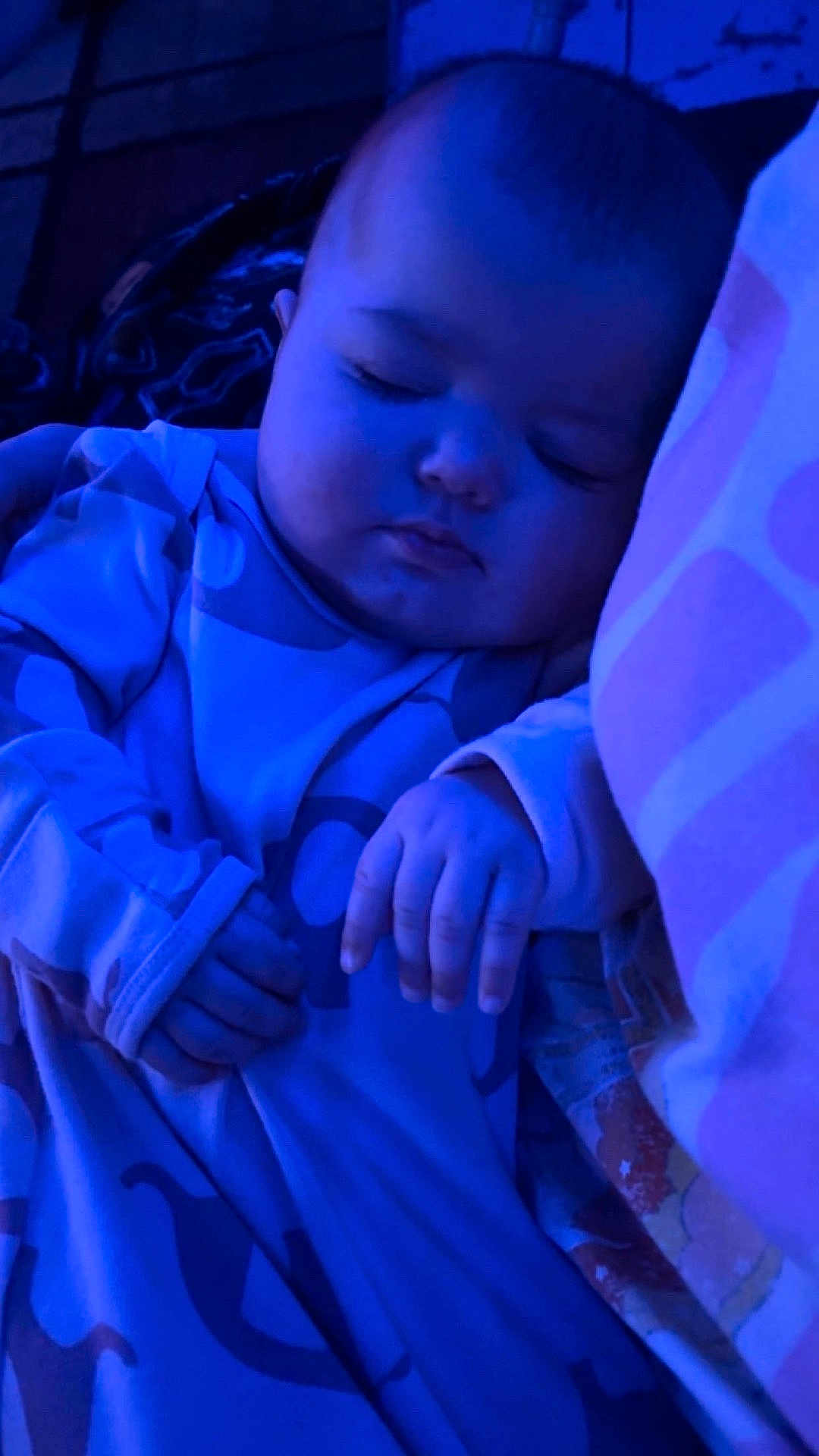 Paisley is registered to the contest to win money with this photo: baby, sleeping_baby, infant, child, asleep, pajamas, blanket, pillow, hand, face, portrait, closeup, head, cozy, cute, peaceful, night_light, blue_tint, bedding, nursery