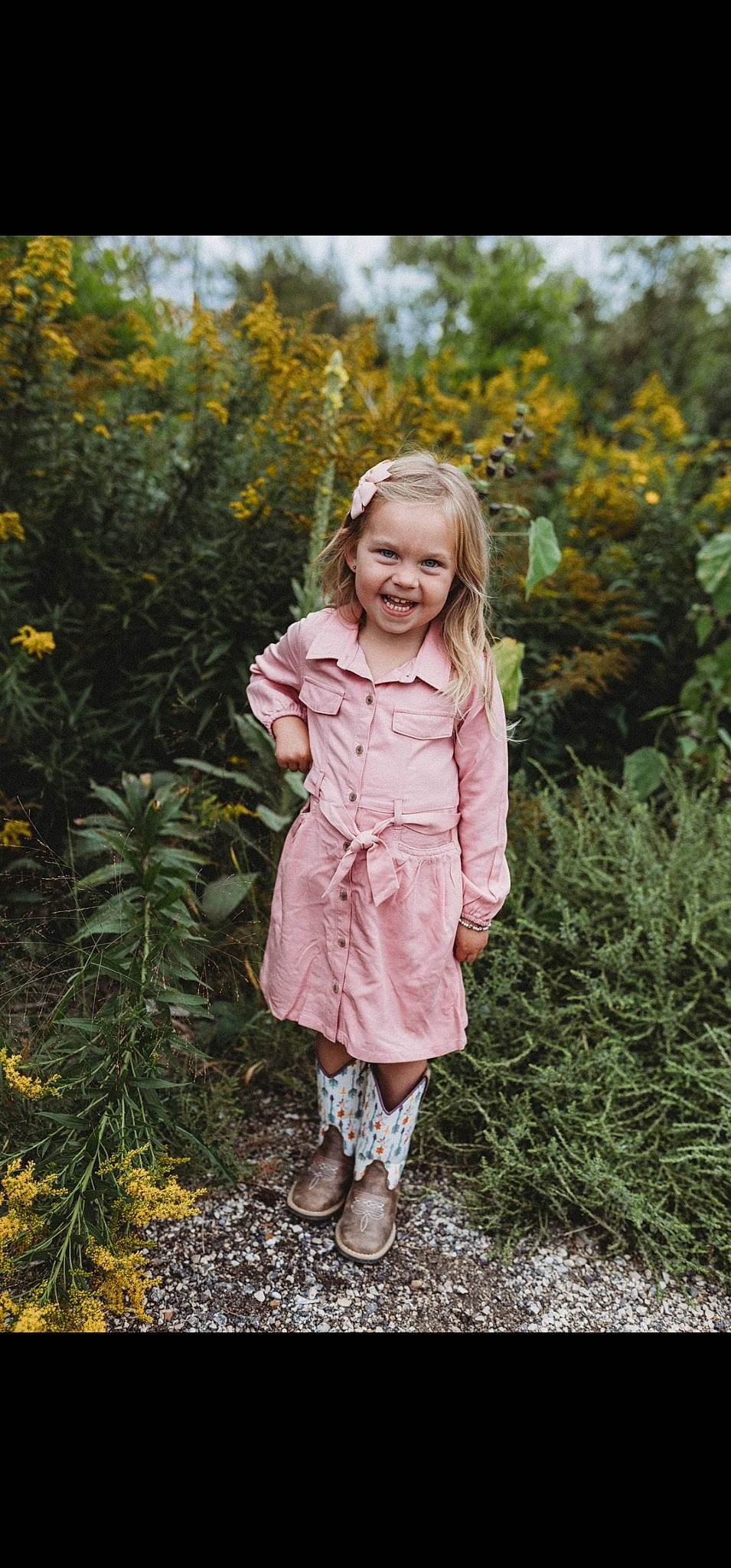 Raegan is registered to the contest to win money with this photo: blond, boot, brown_hair, denim, fawn, forest, fun, fur, grass, hair, happy, jacket, joy, people_in_nature, person, plant, smile, toddler, tree, wildflower