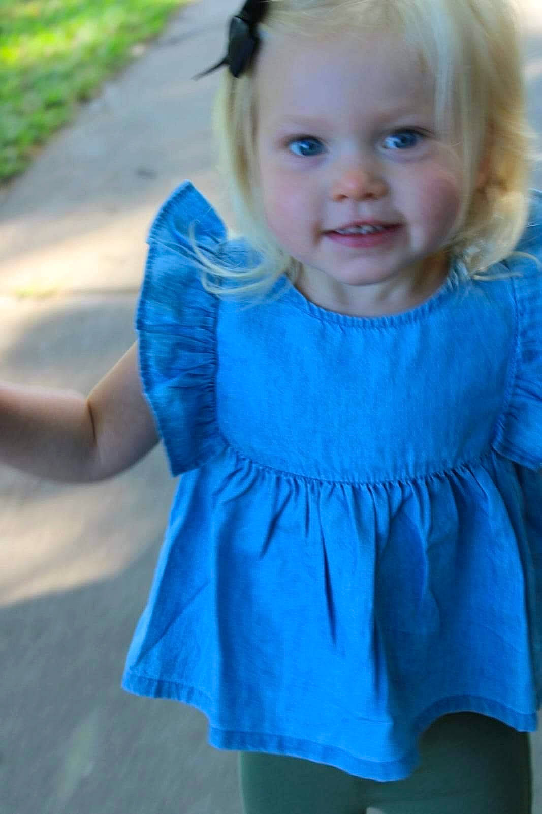 Emersyn is registered to the contest to win money with this photo: azure, baby_toddler_clothing, blue, dress, eye, face, hair, happy, head, iris, joy, outerwear, person, photograph, pink, plant, shoulder, skin, sleeve, smile