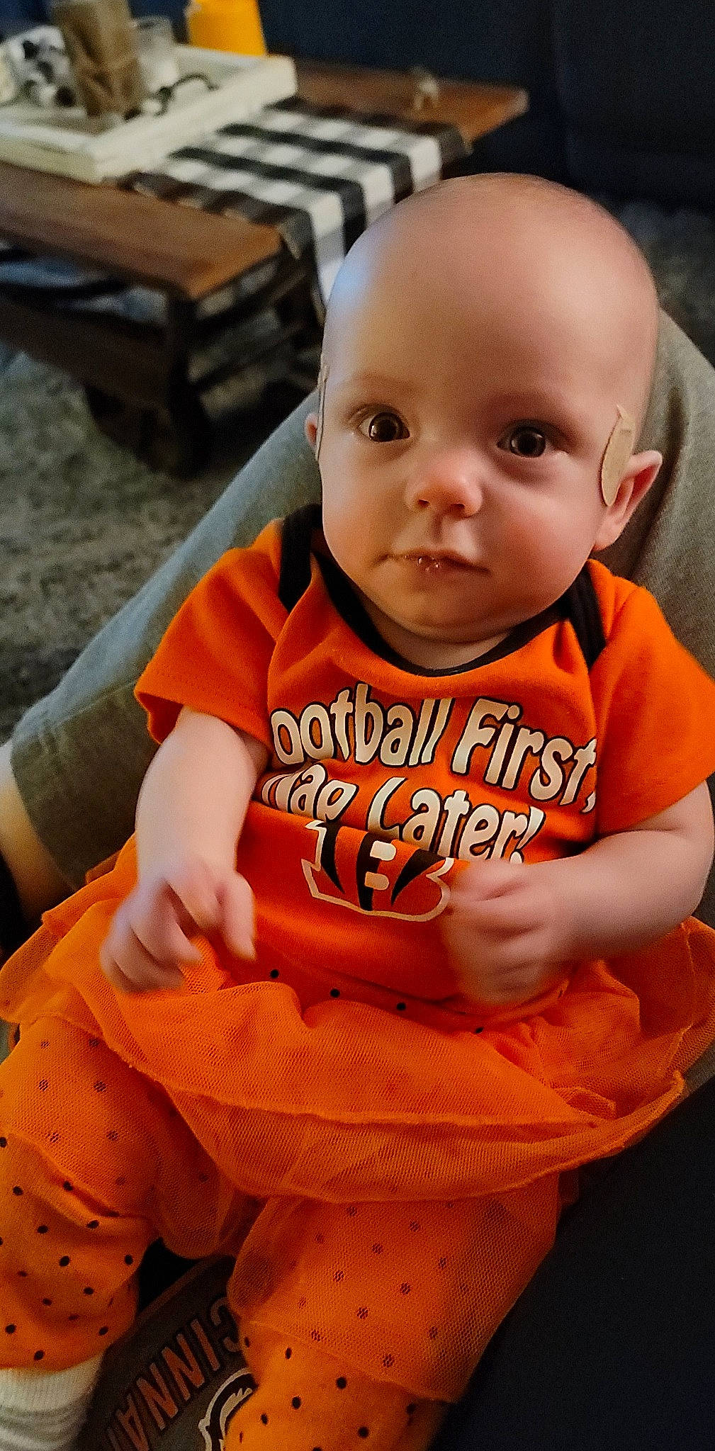 Katara is registered to the contest to win money with this photo: baby, baby_toddler_clothing, bench, cheek, child, chin, cool, fun, happy, head, long_sleeved_t_shirt, mouth, neck, orange, person, sitting, sleeve, smile, sportswear, t_shirt