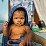 Chavezz joined the competition — help win amazing prizes! baby, child, towel, hood, bed, indoor, skin, cute, portrait, person, infant, expression, hand, foot, blurred_background, curious, sitting, blue, room, soft_light