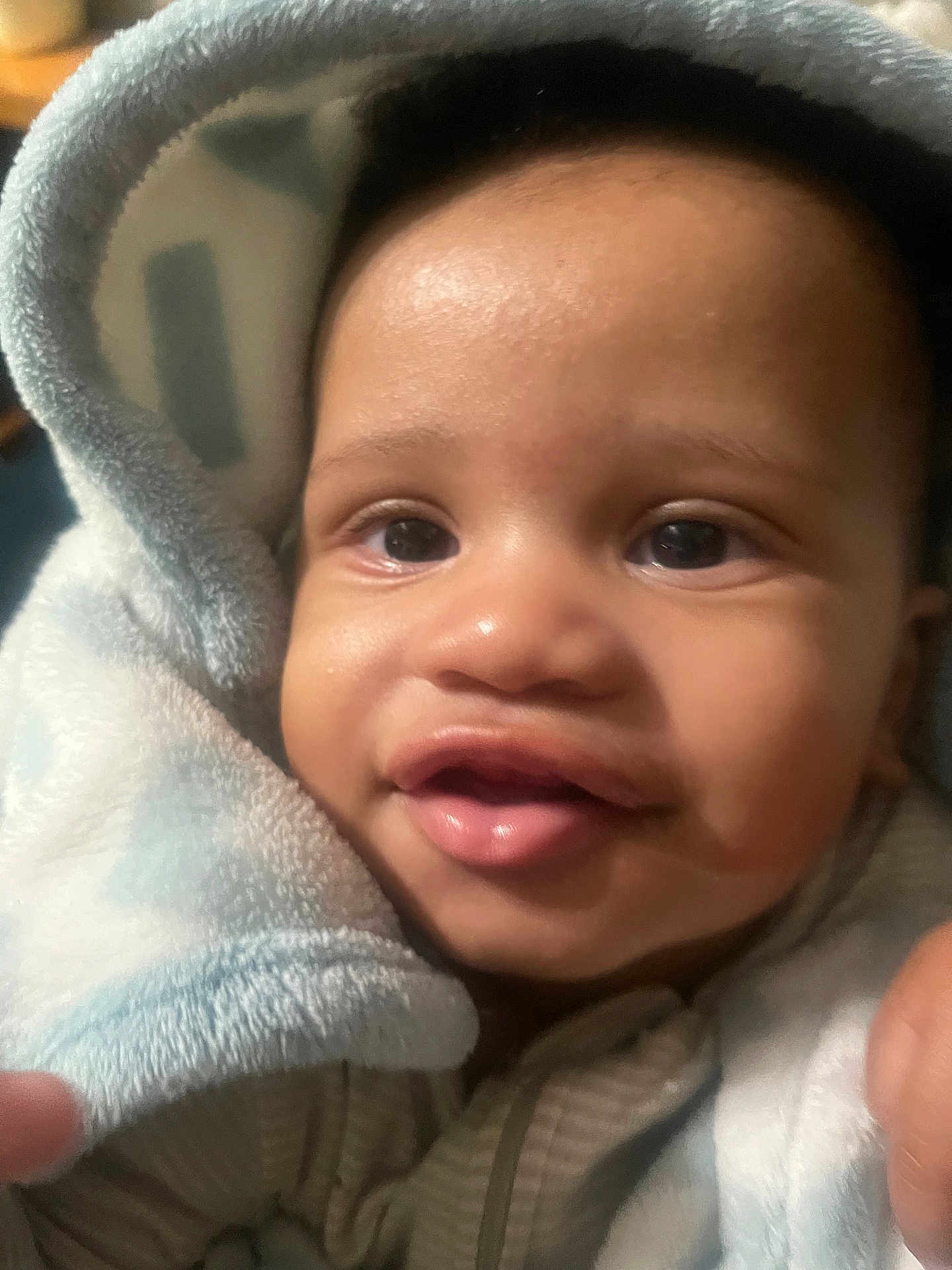 Chavezz is registered to the contest to win money with this photo: baby, infant, face, blanket, soft, cute, closeup, expression, child, skin, hood, warm, cozy, portrait, happy, eyes, mouth, person, indoors, toddler