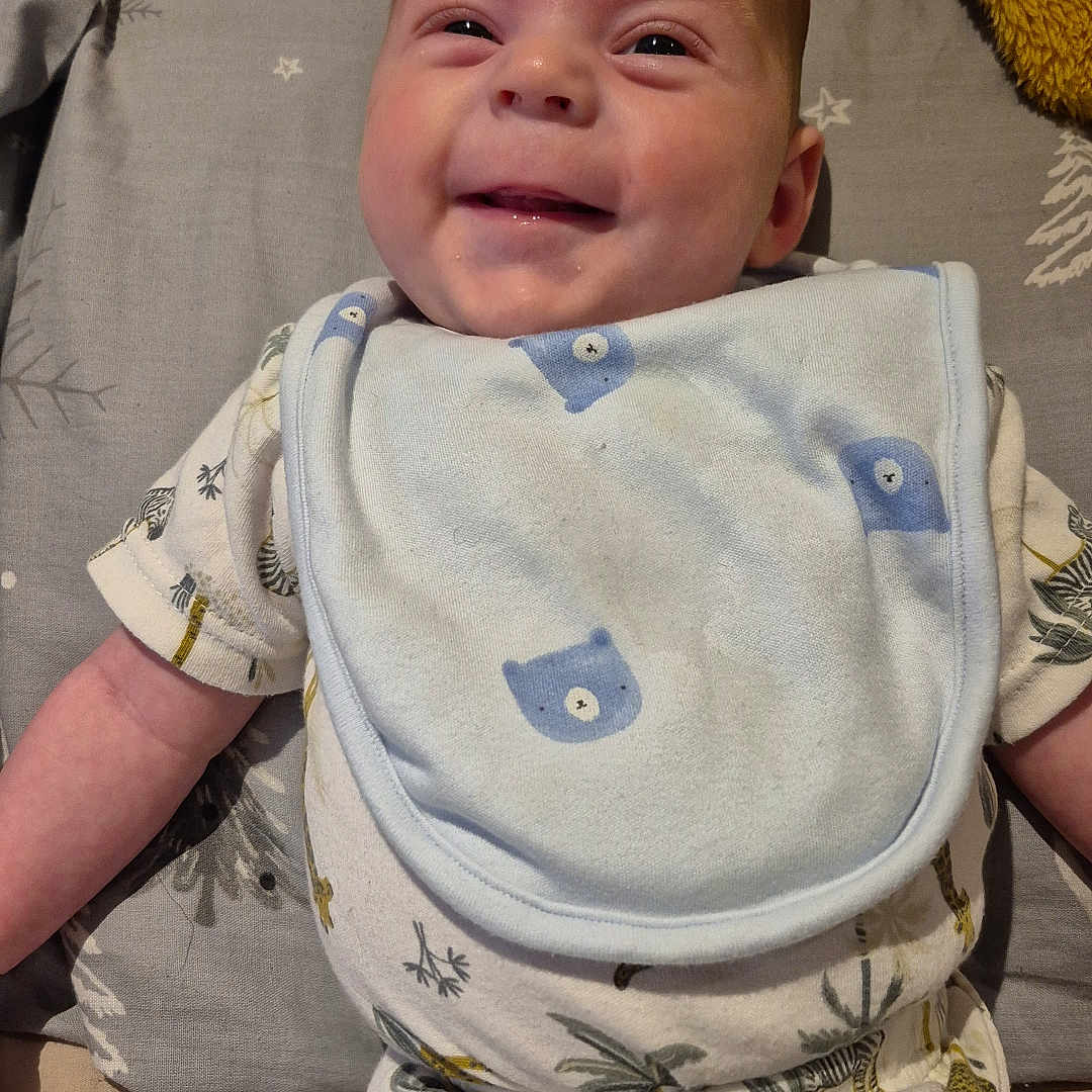 Oscar is registered to the contest to win money with this photo: baby, bed, bedroom, blanket, clothing, couch, crib, cushion, face, furniture, glove, head, homedecor, infantbed, machine, newborn, person, photography, portrait, wheel