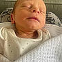 Freddie is registered to the contest to win money with this photo: baby, blanket, closeup, comfort, couch, cozy, face, head, indoors, infant, newborn, peaceful, person, portrait, resting, skin, sleeping, soft_light, white_clothing, young_child