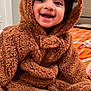 baby, child, smiling, costume, bear, hood, fuzzy, cute, indoors, bedspread, happy, person, portrait, sitting, infant, warm, soft, clothing, face, young