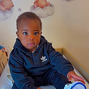 Gustin Erdem a rejoint le concours — aidez-le/la à gagner de superbes lots ! toddler, child, baby, bed, sneakers, hoodie, clothing, indoor, wall_decals, teddy_bear, clouds, nursery, cute, portrait, sitting, person, footwear, expression, room, furniture