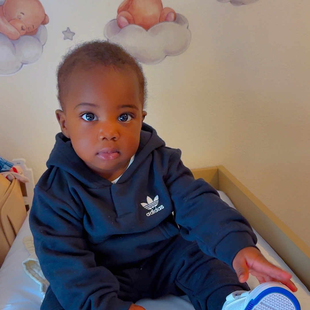 Gustin Erdem a rejoint le concours — aidez-le/la à gagner de superbes lots ! baby, bed, child, clothing, clouds, cute, expression, footwear, furniture, hoodie, indoor, nursery, person, portrait, room, sitting, sneakers, teddy_bear, toddler, wall_decals