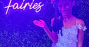 Quiari is registered to the contest to win money with this photo: child, girl, smile, dress, flower_crown, neon_sign, purple_light, fantasy, portrait, posing, event, celebration, greenery_wall, red_carpet, happy, braids, flower, young, costume, magic