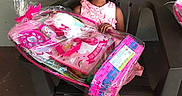 Quiari is registered to the contest to win money with this photo: celebration, chair, child, colorful, excitement, floor, gift_basket, girl, happy, indoor, person, pink_dress, plastic_wrap, portrait, present, sitting, smiling, sparkly_shoes, wall, young