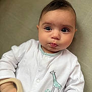 Dahlia Mila is registered to the contest to win money with this photo: baby, infant, onesie, giraffe, embroidery, hand, face, eyes, mouth, skin, clothing, cute, soft, indoors, portrait, child, lying_down, expression, closeup, person